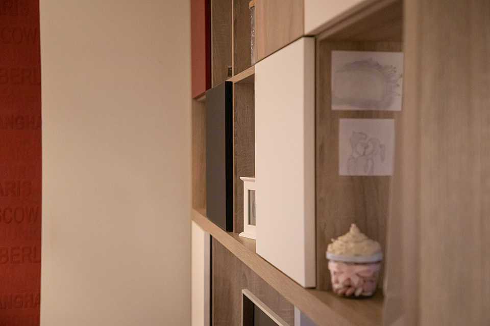 Raumteiler mit quadratischen teils offenen, teils weiß, rot und schwarz verblendeten Fächern